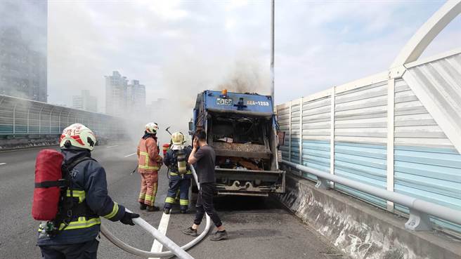一辆民间垃圾车今（19日）上午11时许，行经国道3号北上29公里处、靠近新店隧道口突然起火燃烧，浓烟不断从垃圾车车斗内窜出。（叶书宏翻摄）