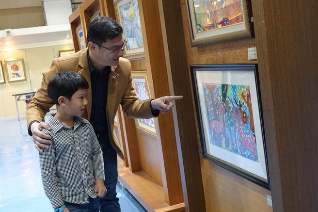 鹿港镇长许志宏（左）至鹿港镇图书艺文中心参观鹿港镇少年、儿童们的画画创作。（谢琼云摄）