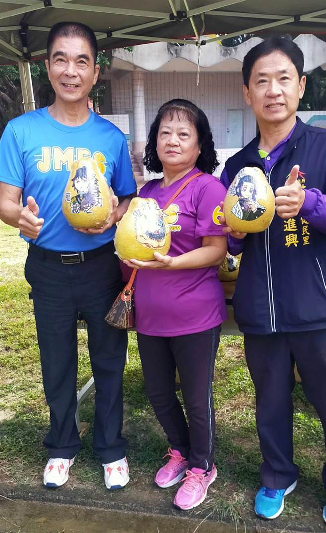 台中市大里区健民里长林进兴（左），已将《鬼灭之刃》彩绘文旦，捐出义卖，义助弱势家庭小孩的书籍费。（林进兴提供／黄国峰台中传真）