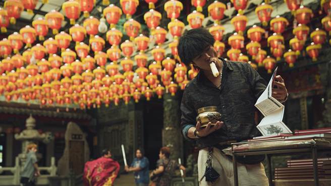 邱澤在《當男人戀愛時》中邊討債邊啃甘蔗。（金盞花大影業提供）