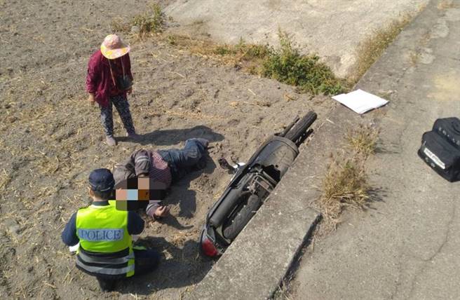 警方沿线搜索，在靠近同安西巷堤防边坡田埂处，发现1台重机车横倒在田地内，1名男子趴在田地上，面部朝下，左腿遭机车压住动弹不得。（警方提供／陈世宗台中传真）