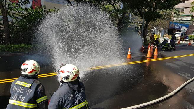 消防人员拉起水线，洒水降温防护。（王扬杰翻摄）