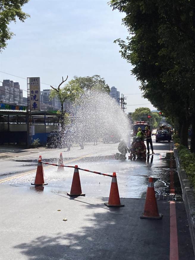 消防人员拉起水线，洒水降温防护。（王扬杰翻摄）