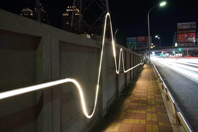 新竹市政府近日在光復路与慈云路交叉口的台电新竹一次变电所围墙，装上心电图状的动态「光雕」，以弯曲钢条搭配LED线灯，让变电所变有趣。（陈育贤摄）