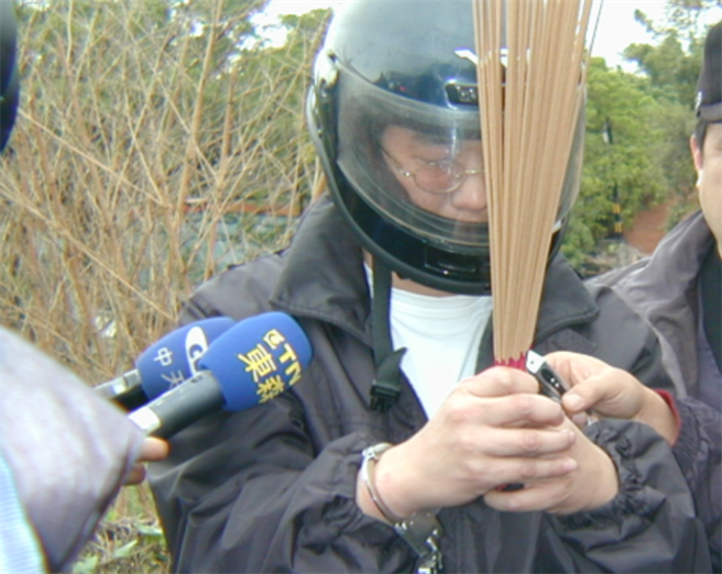 杀妻分尸案嫌犯王熙宏（中），被捕后在弃置尸块的垃圾车旁向亡妻上香祭拜。（中时资料照）