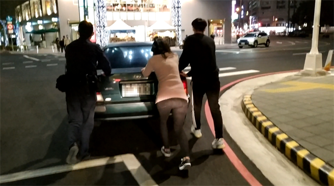 「MAN POWER」員警（圖左），合力將車安全推至路邊，助民「一臂之力」。（讀者提供／張妍溱台中傳真）