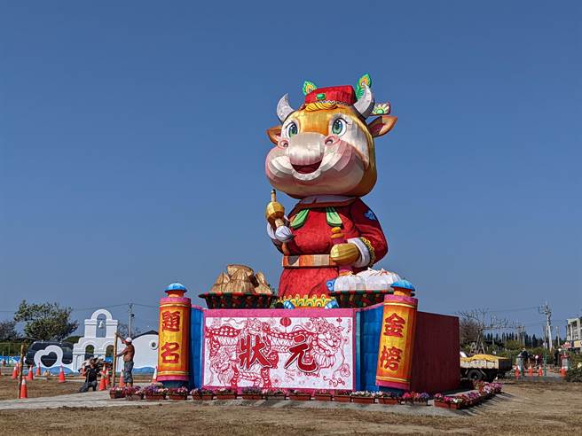 台湾灯会因疫情停办，4层楼高的副灯「犊站金榜」移置到台南北门游客中心外的大草坪，26日元宵夜将正式点灯展示，金牛头戴状元帽、手拿文笔，造型可爱，相当吸睛。（庄曜聪摄）