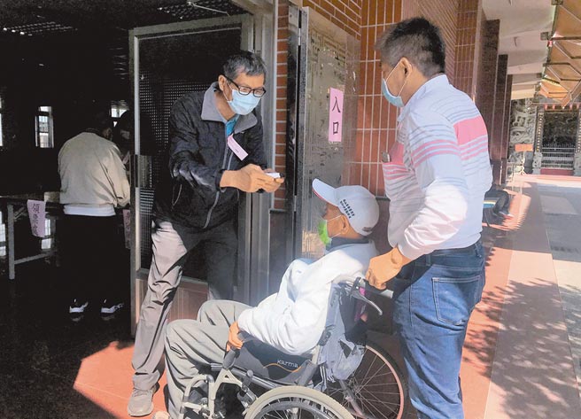 全台基层农会改选21日举行，农会会员到冈山区的投开票所投票，选务人员为会员量测额温。（林瑞益摄）