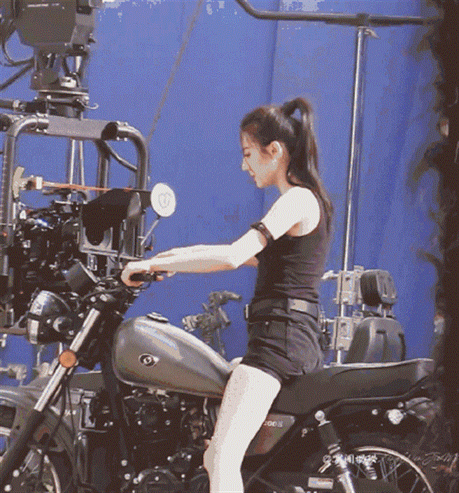 迪丽热巴绑着高马尾，身穿贴身的黑色深U背心搭背超短热裤拍广告。（图／取材自新浪娱乐）