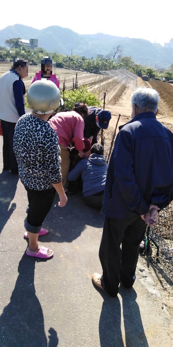 9旬游姓老嫗昏倒於田間小路，新北市金山警分局警員前往協助。（金山警分局提供）