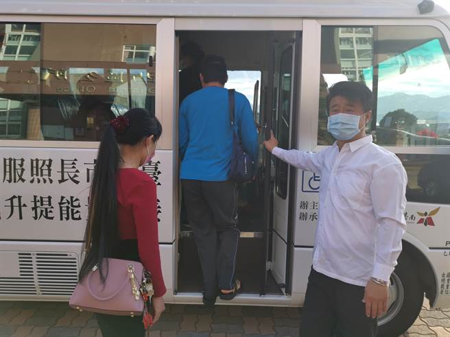 台南市楠西區長照就醫接送專車，23日首班專車8點20分出發，區長李鴻裕（右）協助長輩上車就坐。（劉秀芬攝）
