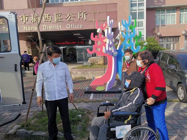 台南市楠西區長照就醫接送專車，23日首班專車8點20分出發，區長李鴻裕（左）協助長輩上車就坐。（劉秀芬攝）