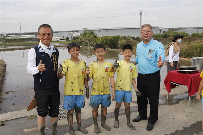 大里農會23日舉行「作伙插秧趣」活動，大里國小的小朋友們實際下田體驗插秧後，大里農會總幹事賴東陽（右）、大里國小校長蔡添元（左），勉勵小朋友們，要珍惜食物。（大里農會提供／黃國峰台中傳真）