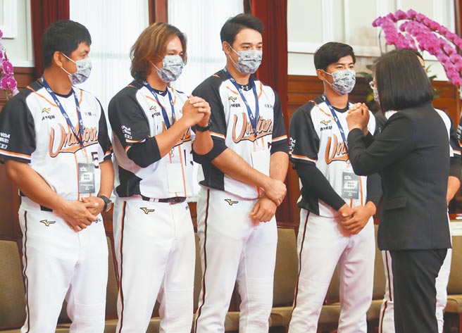 蔡英文总统（前右）接见去年中职总冠军统一狮队，并与球员拱手致意。（中央社）