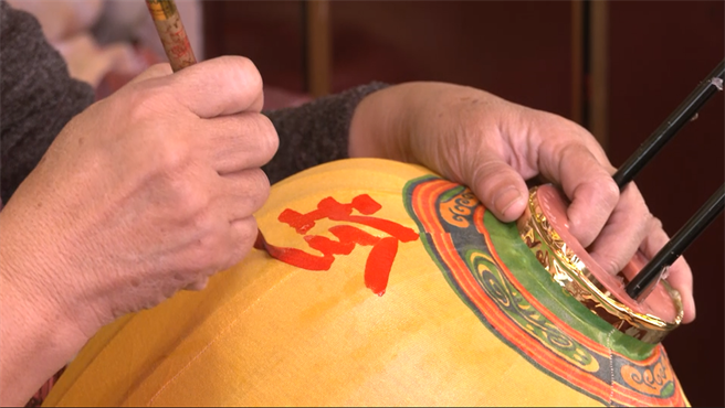 师傅在灯罩上写上漂亮书法。(摄影/邱子轩)