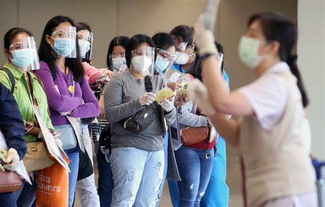 在桃園機場入境管制區內，一群剛下機的菲籍移工，在專人引導下準備通關入境。（范揚光攝）
