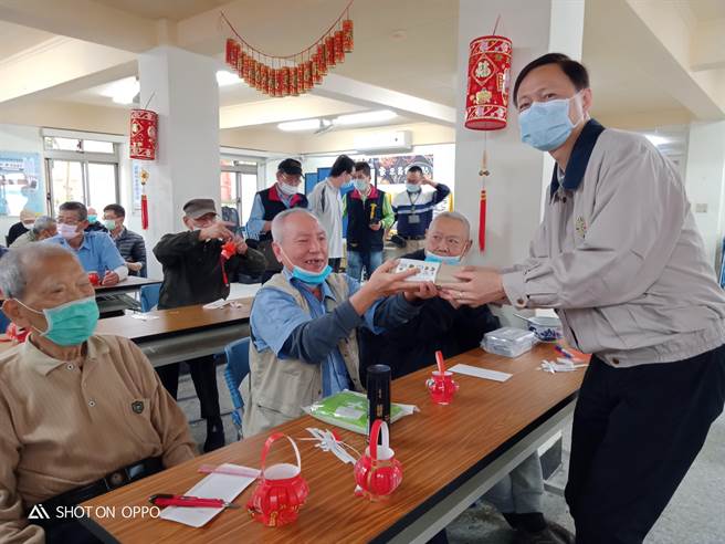 台北荣家主任刘化宇(右)亲自颁发灯谜奖品给荣民伯伯。(台北荣家提供)