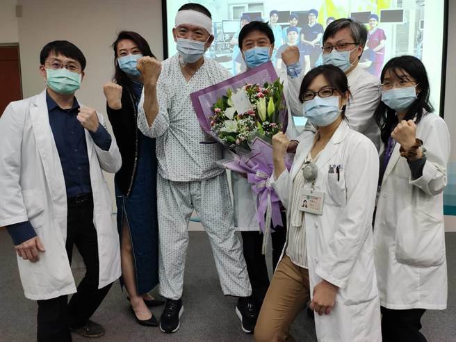 陳姓室內設計師（左3）接受腦幹摘除水瘤手術，術後6天，即可下床活動，25日在妻子陪同下，到台中榮總獻花感謝醫療團隊。（張妍溱攝）