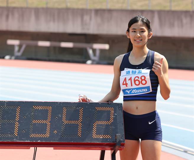 聽障跨欄女將許樂在港都盃高女100公尺跨欄摘金，賽後與參考成績合影。（中華田徑協會提供）