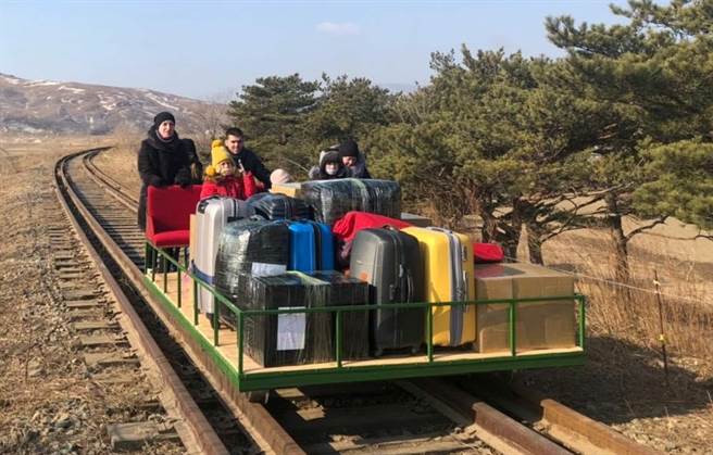 俄罗斯大使馆三等秘书索罗金（Vladislav Sorokin）推着轨道台车，带着成堆行李和同僚家属，歷经1公里的旅程后，才终于穿越边境返国。（路透）