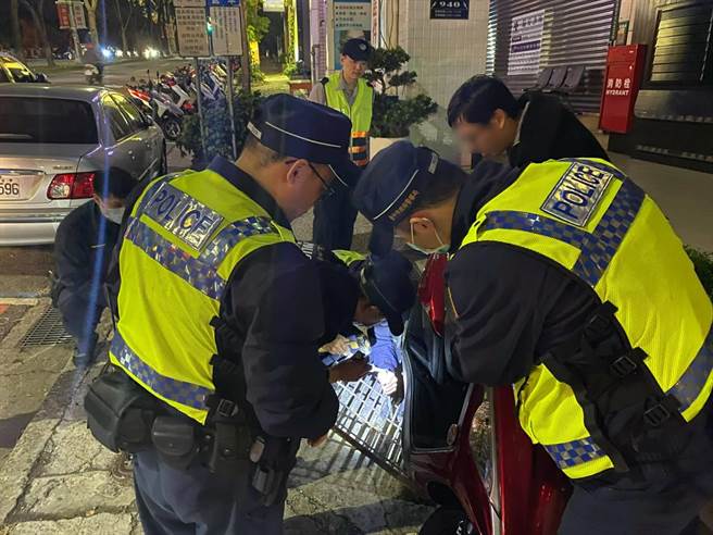 民眾的机车中柱在水沟盖「卡紧卡满」，分离困难度高，员警用槌子对着卡在水沟盖上的中柱上又敲又打。（民眾提供／卢金足台中报导）