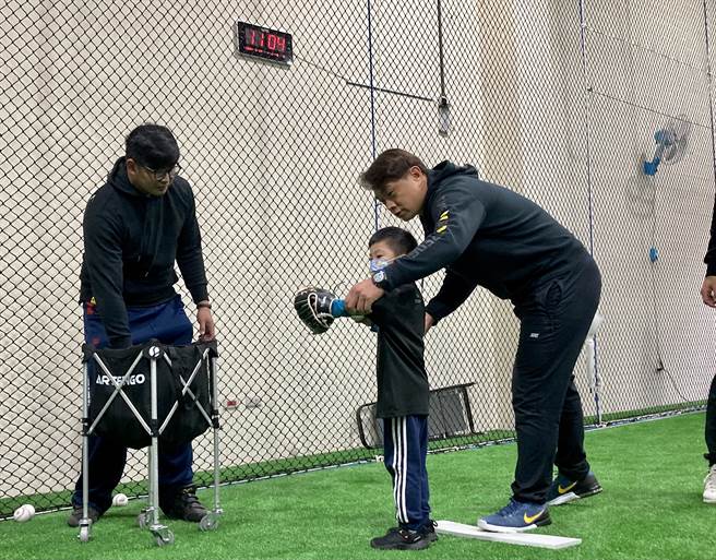 彭政闵创立「恰棒球学苑」，贴身指导小朋友投球。（邓心瑜摄）