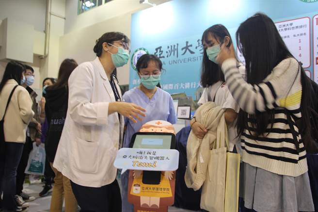 亚洲大学防治失智照护机器人「Temi」，在大博会中与考生互动，该校护理学院院长吴桦姗（左）在旁解说，展现AI教学跨域运用成果。（亚大提供／林欣仪台中传真）