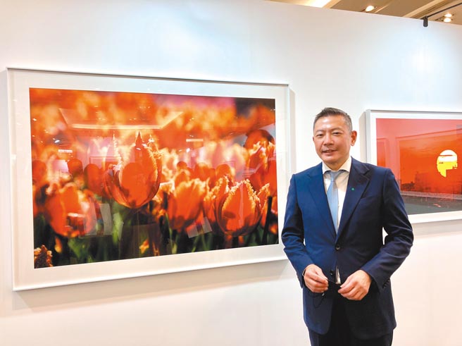 新光三越国际摄影联展即日起全台巡展，新光三越副董暨总经理吴昕阳于父亲吴东兴最后摄影遗作前留影心情依旧激动。图／李丽满