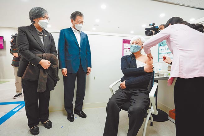 韩国昨启动新冠肺炎疫苗接种工作，鼓励一线医护人员施打，图为韩国总统文在寅（中）26日在首尔一处公共卫生中心观看一名医生接受AZ疫苗注射。（路透）