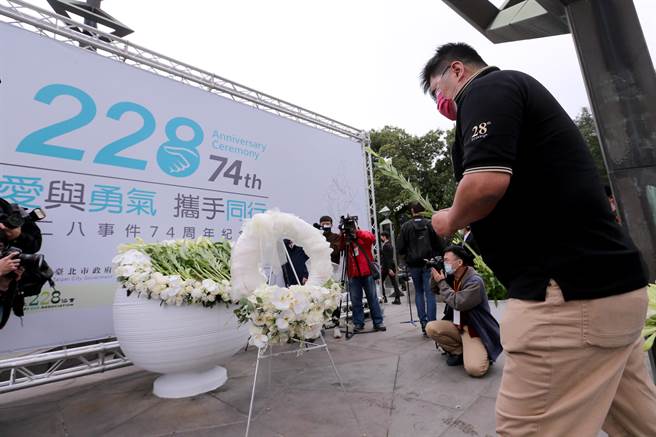 台北市政府28日举办228事件74周年纪念会，出席民眾将百合花放在纪念碑文上，吊念当年牺牲生命的罹难者。（黄世麒摄）