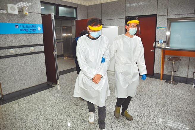 连姓男子（左）在居家检疫最后1天，偷跑外出贩毒，警方戒护时让他穿上头罩及防护衣。（警方提供）