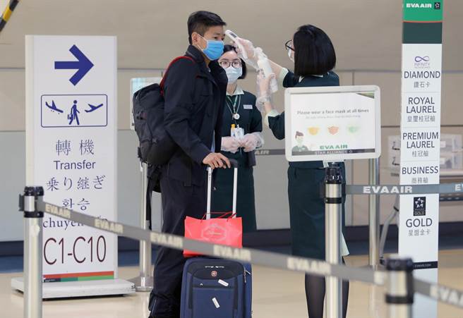 1日起放寬非本國籍人士入境條件、恢復短期商務入台縮短檢疫申請等，新政策上路的第一天，就有旅客經台灣轉機赴美，大讚還是台灣方便，不但安全，也可以節省很多轉機的銜接時間。圖為航空公司地勤人員為轉機旅客量測額溫。（陳麒全攝）
