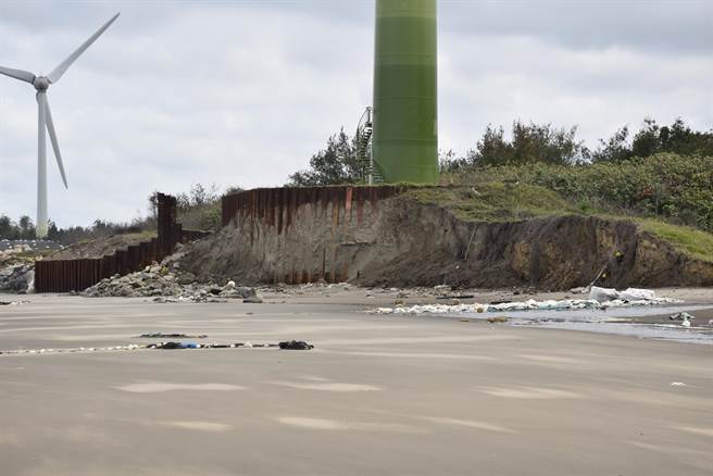 龙凤渔港南堤旁一座风力发电机基座积沙已被淘空，基座护椿都裸露生锈。（谢明俊摄）