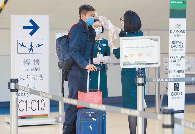 3月1日起放宽非本国籍人士入境条件、恢復短期商务入台缩短检疫申请等，新政策上路的第1天，就有旅客经台湾转机赴美。图为航空公司地勤人员为转机旅客量测额温。（陈麒全摄）