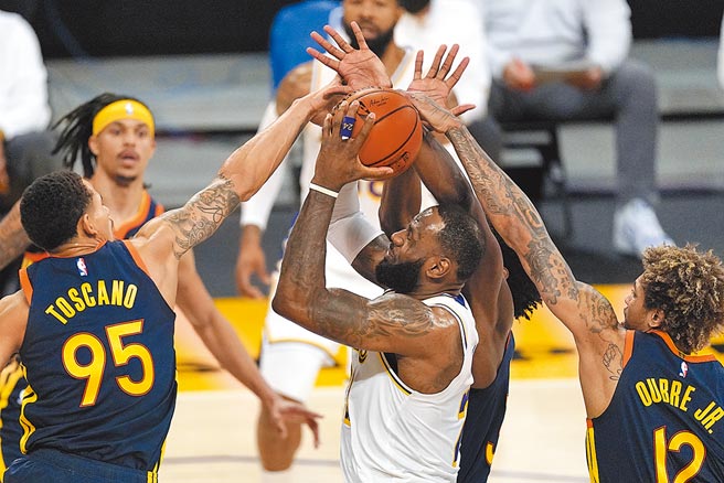 湖人前锋詹姆斯（中）想要持球切入，却碰到3名勇士球员联防，几乎没有出手空间。（美联社）