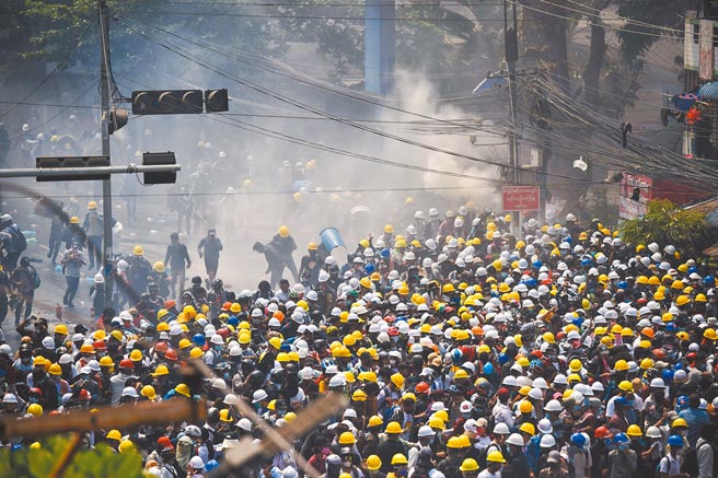 在仰光，数以千计的抗议人潮走上街头和军警对峙，当局则对示威人士发射催泪弹。（路透）