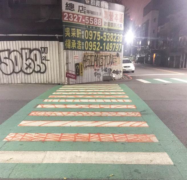 东兴国小外侧绿色斑马线及围墙铁门遭喷漆涂鸦。（警方提供）