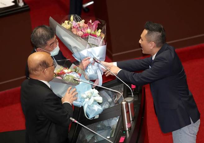 立委陳以信（右）5日在立法院質詢時，特別準備了兩束花，代表人民感謝行政院長蘇貞昌（左）與衛福部長陳時中（中），感謝政府及第一線的防疫人員在新冠肺炎防疫上的成就與努力。（鄭任南攝）