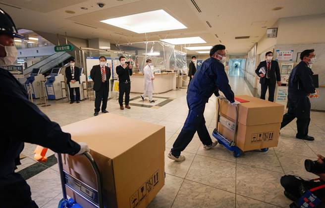 在疫情严重下，日本防疫公务员疲于奔命，有人的单月加班时数甚至高达391小时。图为日本防疫工作人员运送新冠肺炎疫苗。（图/路透社）