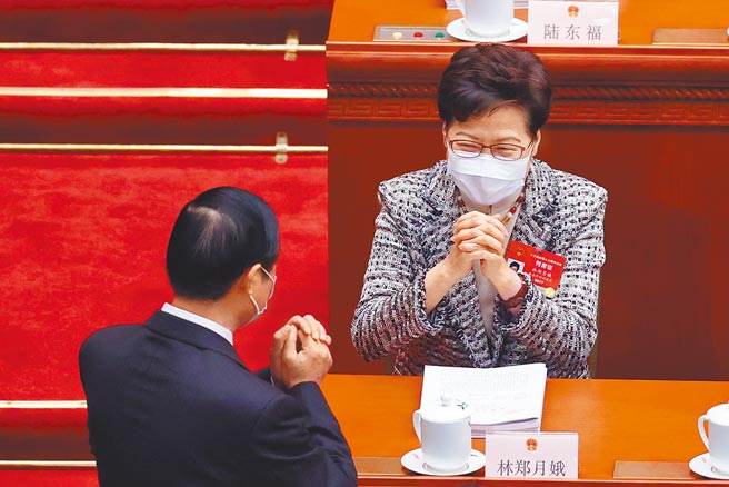 3月5日，中共第十三届全国人民代表大会第四次会议在北京人民大会堂开幕，香港特首林郑月娥（右）列席开幕式。（中新社）