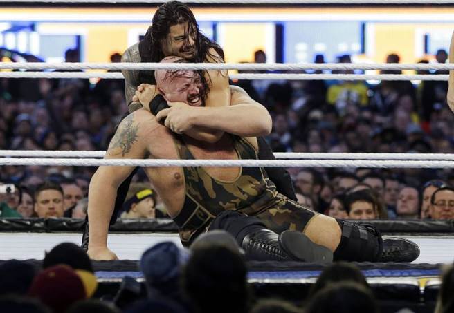 大秀哥(Big Show)在擂台上被对手Roman Reigns锁头。（美联社资料照）