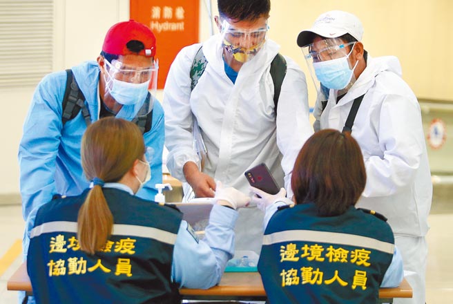 中央流行疫情指挥中心6日公布，国内新增7例境外移入新冠肺炎确定病例，皆为东南亚渔工。图为桃机防疫人员查验入境旅客的健康资料。（本报资料照片）