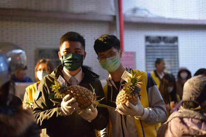 民进党新竹市党部主委陈建名（左）吁请大家一起来吃凤梨挺农民，共同向全世界推销台湾凤梨。（陈育贤摄）