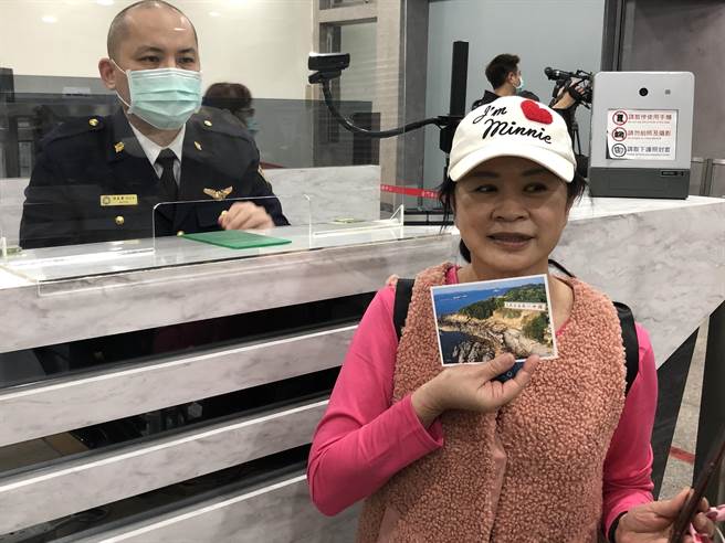 游客获赠盖有偽出国纪念戳章的金门风景明信片，留下海上金门行的美好回忆。（李金生摄）