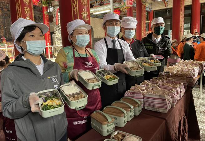 新竹市于本月2日起陆续恢復关怀据点、共餐食堂等服务，市长林智坚（中）10日特别到港南好邻居关怀协会了解开站现况，并帮长辈打菜。（陈育贤摄）