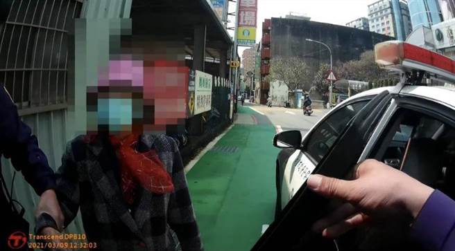 81歲老婦因提菜太重跌坐在路邊，在暖警協助下順利返家。（姜霏翻攝）