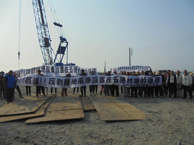 雲林縣台西鄉五港村村民抗議風力發電機組過於接近房舍與墓地，舉白布條抗議。（民眾提供／張朝欣雲林傳真）