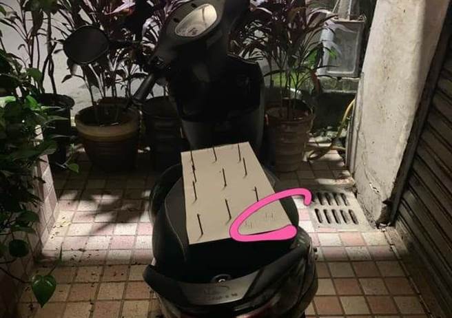 1名网友在路上目击，某辆机车坐垫上摆放1张白色纸板，纸板上竟放着10根尖端朝上的大铁钉，纸板角落处还有4根细小铁钉，让他直呼相当危险。（图／翻摄自脸书「爆怨公社」）