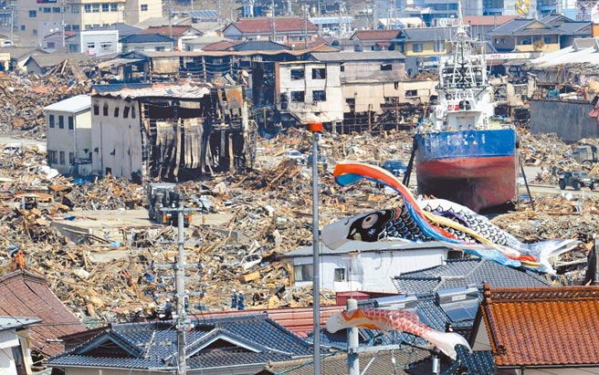 日本福岛311核灾10年，图为2011福岛在强震后掀起海啸，冲毁无数民宅，渔船也被冲到陆地，福岛核电厂发生核外泄，造成灾变。（美联社）