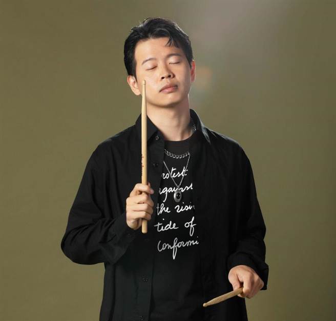 圖四：堂軒穿上agnes b服裝，並手持鼓棒隨著當天拍攝時播放的音樂起舞。（石智中攝）